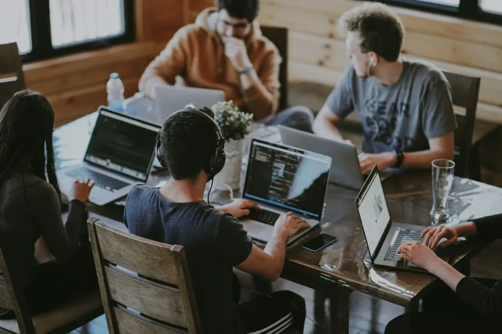 Digital agency team working together on laptops around a table